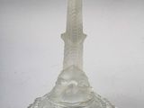 a clear glass candle holder with a bird on top of it