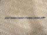 a silver bracelet that is on a wooden floor