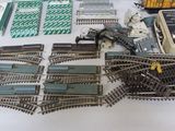 a lot of train tracks and other toy trains on the table