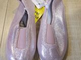 pair of pink ballet shoes sitting on top of a wooden floor