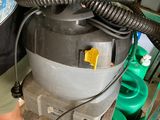 a man standing next to a machine with a hose attached to it