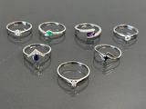 several different rings are arranged in a row on a table