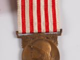 a gold medal with a red and white ribbon around it