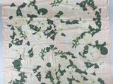 un motif floral blanc et vert sur une couverture rose et blanche