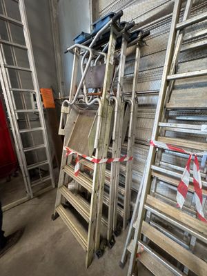 many ladders that are stacked up in a room