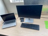 un ordinateur portable et un écran posés sur un bureau, à côté d'un clavier et d'une souris