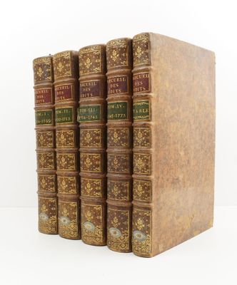 trois livres sont empilés sur une surface blanche