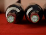 three bottles of wine are lined up on a red table