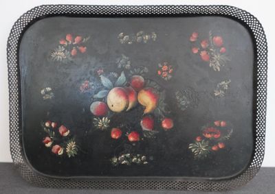 un plateau noir avec des fruits posé sur une table