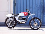 a white and red motorcycle parked in front of a blue garage door