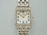 une montre en argent avec un cadran blanc et des diamants