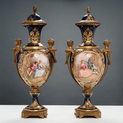une paire de vases anciens ornés de scènes peintes, posés sur une table
