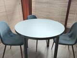 une table blanche et des chaises bleues dans une pièce