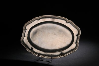 un plateau d'argent antique sur un support sur fond noir