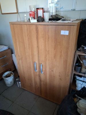 a cabinet in the corner of a room with a lot of clutter on it