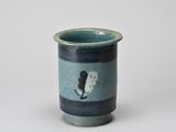 a small cup with a cat on it on a table