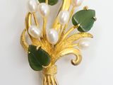 broche dorée ornée de fleurs vertes et blanches et de perles