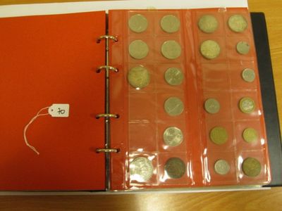 un classeur rouge contenant des pièces de monnaie, posé sur une table