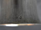 a close up of a silver bell hanging from a ceiling light