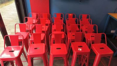 de nombreux tabourets rouges dans une pièce où une télévision est accrochée au mur