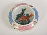 a small bowl with two fish in it on a table