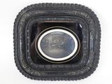 a black plate with a picture in it on a white wall