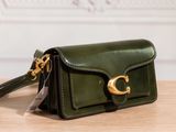a close up of a green purse on a wooden table