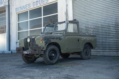 un vieux véhicule militaire garé devant un immeuble