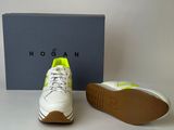 the shoe is white and green with a yellow sole
