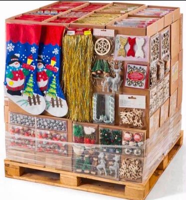une caisse en bois remplie de décorations de Noël posée sur une palette