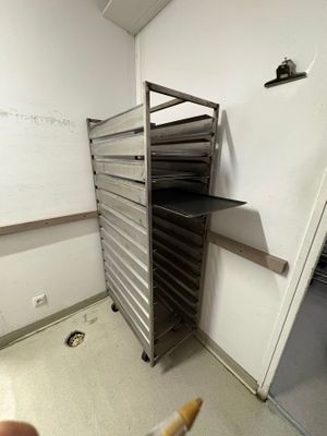 a person holding a cigarette in front of a rack of trays