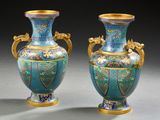 pair of blue and gold vases sitting on a gray surface