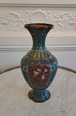 un vase posé sur une table, avec un mur blanc en arrière-plan