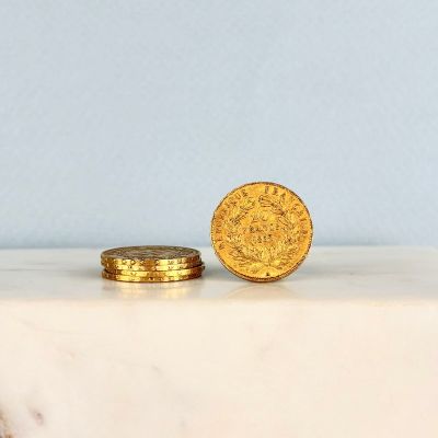 deux pièces d'or posées sur une dalle de marbre