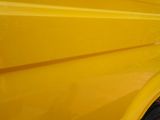 a yellow truck parked in a parking lot next to a building