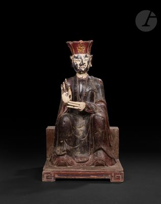une statue en bois représentant un homme assis, coiffé d'une couronne