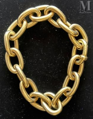 a close up of a gold chain bracelet on a black surface