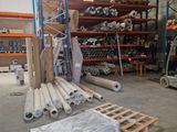 many rolls of paper sitting on pallets in a warehouse