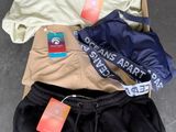three pairs of pants and a t - shirt laying on the floor