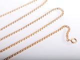 a gold chain that is laying on top of a white table