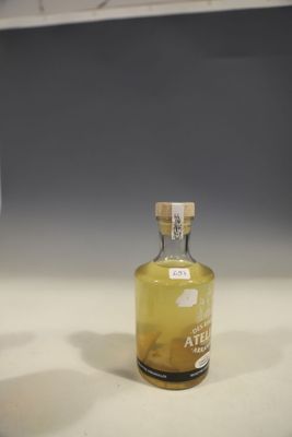 une bouteille d'alcool posée sur un comptoir à côté d'un verre de vin