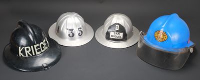 trois casques de pompier posés les uns à côté des autres sur une table