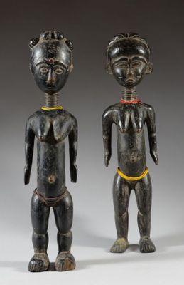 two wooden figures of a man and a woman standing next to each other