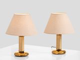 pair of brass table lamps with linen shades on a white table