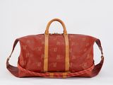 a red duffel bag sitting on a white surface