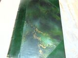 a green book sitting on top of a white table cloth