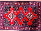 a red and blue rug with geometric designs on it