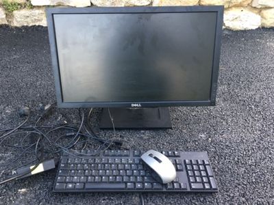 un écran d'ordinateur, un clavier et une souris posés par terre