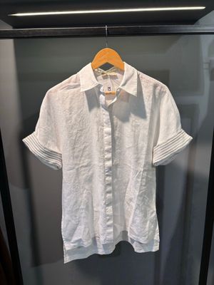 une chemise blanche suspendue à un cintre dans une vitrine