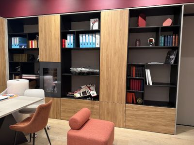 a desk with a chair and a book shelf in the corner